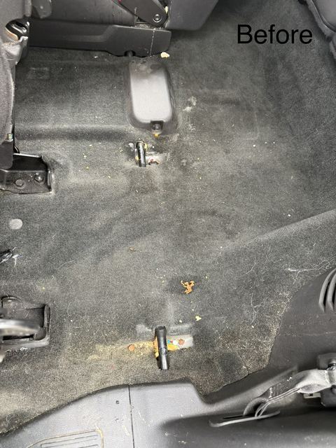 Dirty rear carpet floor of a vehicle with crumbs and debris, before detailing (labeled 'Before')