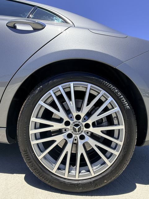 Close-up of a Mercedes-Benz multi-spoke alloy wheel with Bridgestone tire on a gray car