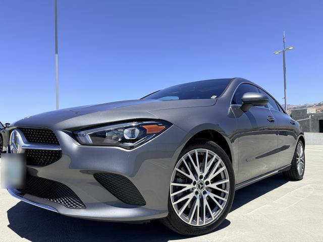 Gray Mercedes-Benz CLA, low-angle front three-quarter view on a rooftop parking deck