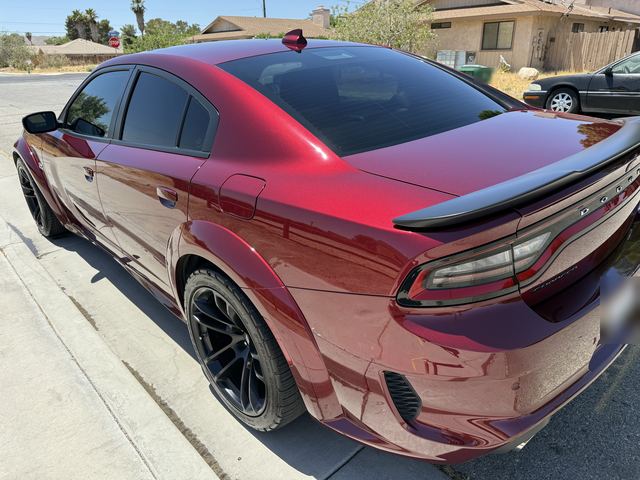 Dark red Dodge Charger, rear three-quarter view on a residential street