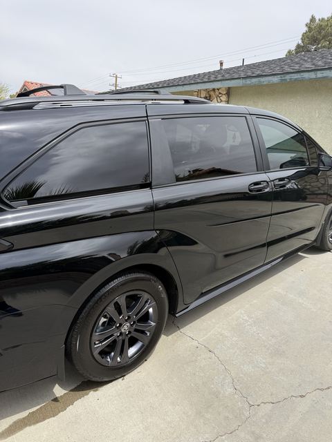 Black Toyota minivan, side view on a driveway