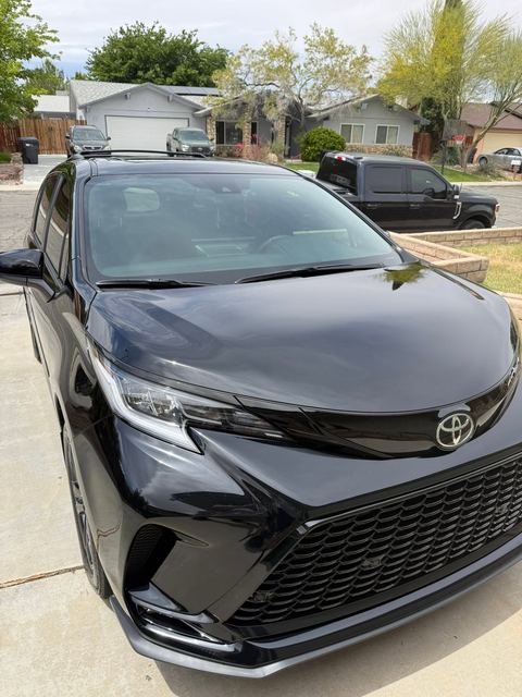 Black Toyota minivan, front view on a driveway