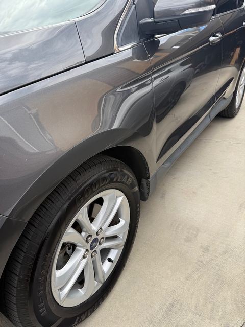 Dark gray Ford SUV front fender and silver alloy wheel with Goodyear tire
