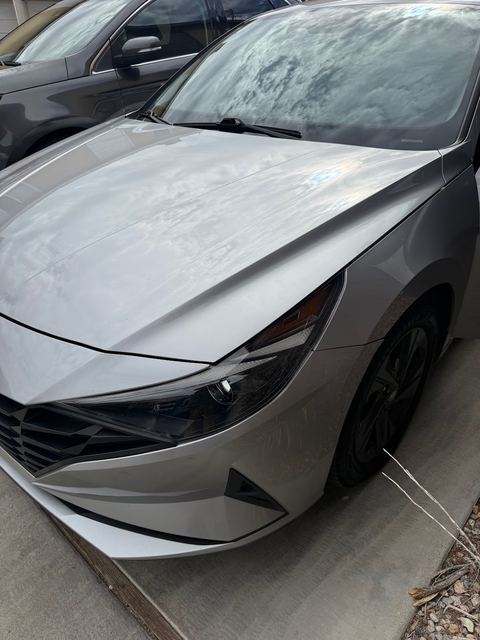 Silver sedan front corner showing hood, headlight and wheel