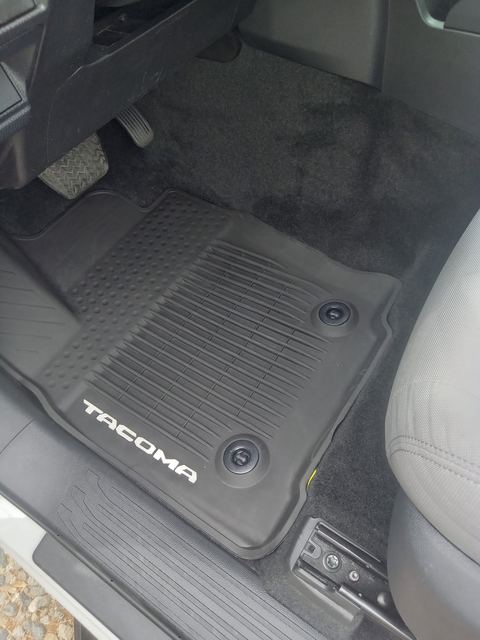 Black rubber Toyota Tacoma floor mat and carpet on the driver side